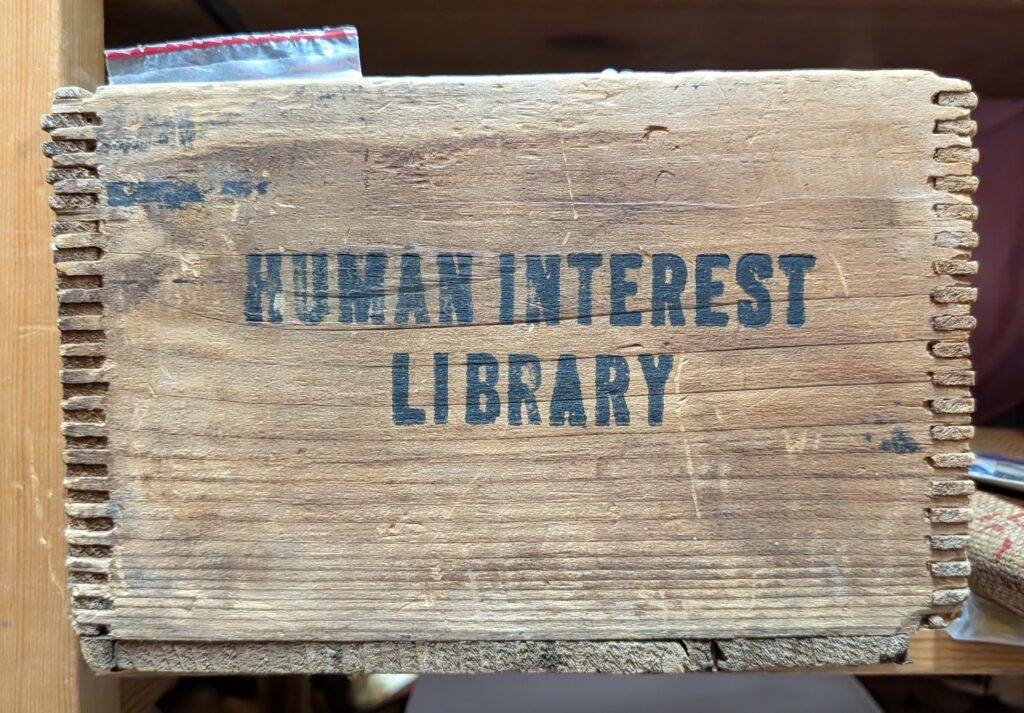 A wooden box labeled "Human Interest Library"